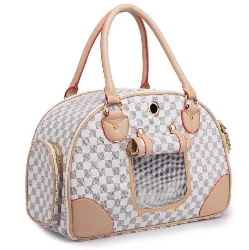 A pet carrier bag with a gray and white checkered pattern, beige leather handles and trim, and a clear window on the front.