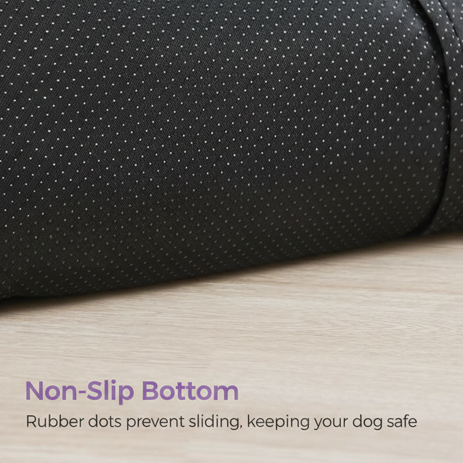 Feature infographic showing a close-up of the black perforated rubber dot non-slip base of a long shaggy faux fur pet sofa bed resting on a light wood floor, with lavender text: Non-Slip Bottom — Rubber dots prevent sliding, keeping your dog safe