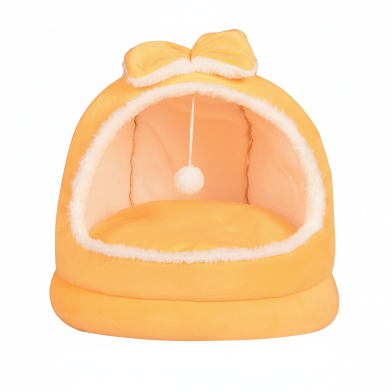 Yellow plush dome cat bed with matching orange bow on top, hanging white pom pom ball, cream fluffy interior lining, on a clean white background