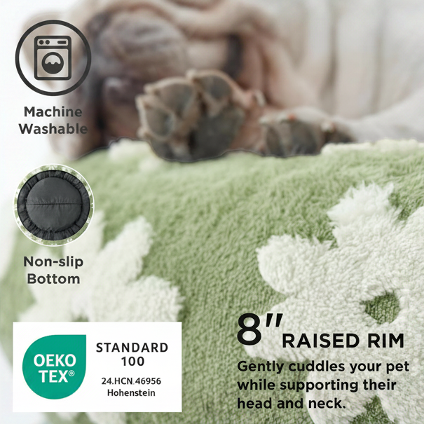 Feature callout infographic for a sage green daisy-print plush round donut pet bed, showing a close-up of a sleeping dog's paws on the bed surface, with three callouts: Machine Washable (washing machine icon), Non-slip Bottom (rubber bottom close-up), OEKO-TEX Standard 100 certified (24.HCN 46956 Hohenstein), and bold text reading 8" Raised Rim — Gently cuddles your pet while supporting their head and nec