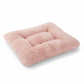 Blush pink long shaggy faux fur square tufted flat pet bed mat shown at a 3/4 angle on a white background