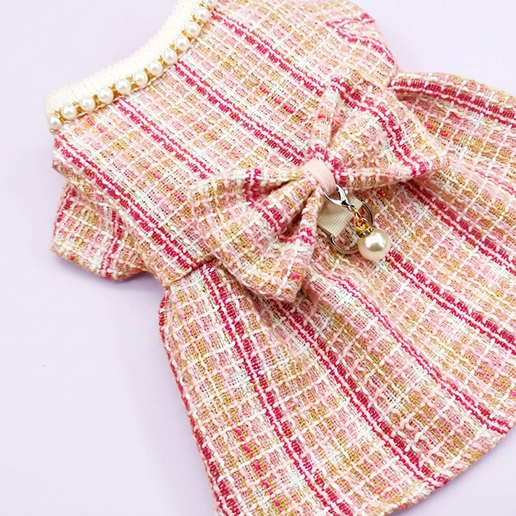 Pink tweed dress close-up on a very pale lavender background