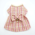 Pink tweed dress straightened with bow and pearl-style charm attached on white