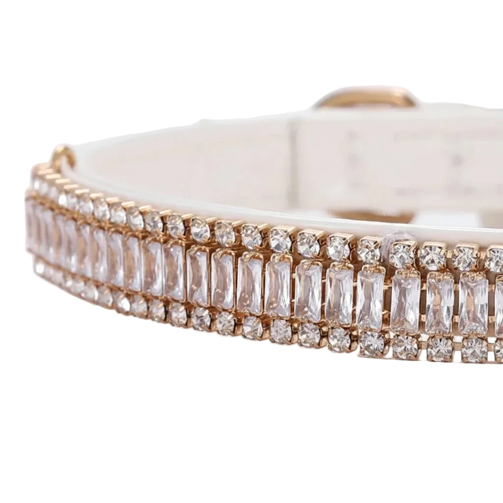 Pretty Posh Pets luxury rhinestone pet collar — close-up detail of a white leather collar featuring a row of emerald-cut clear crystal baguette gemstones bordered by two rows of sparkling round rhinestones set in rose gold, showcasing the intricate jewel setting and premium craftsmanship on a white background.