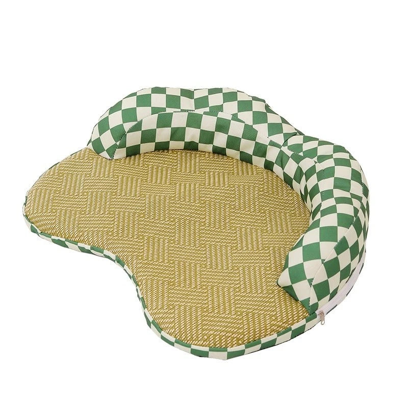 A contoured pet bed featuring a green and cream checkered fabric bolster and a textured tan woven mat on a white background.