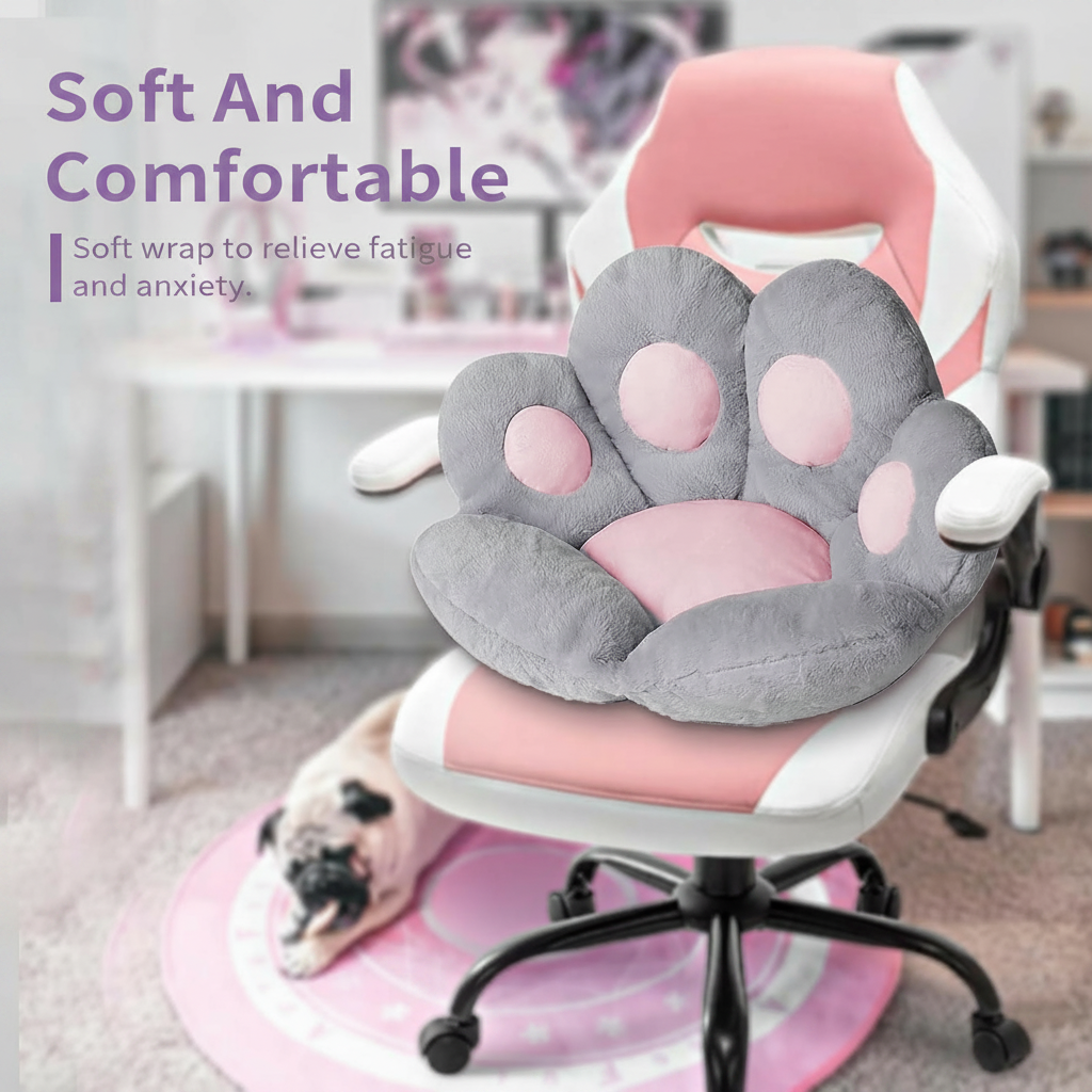 Lifestyle infographic with lavender text reading Soft And Comfortable — Soft wrap to relieve fatigue and anxiety, showing a grey and pink plush paw-shaped cushion seated on a pink and white gaming chair, with a small Pug puppy resting on a pink round mat beneath the chair in a bright pastel room
