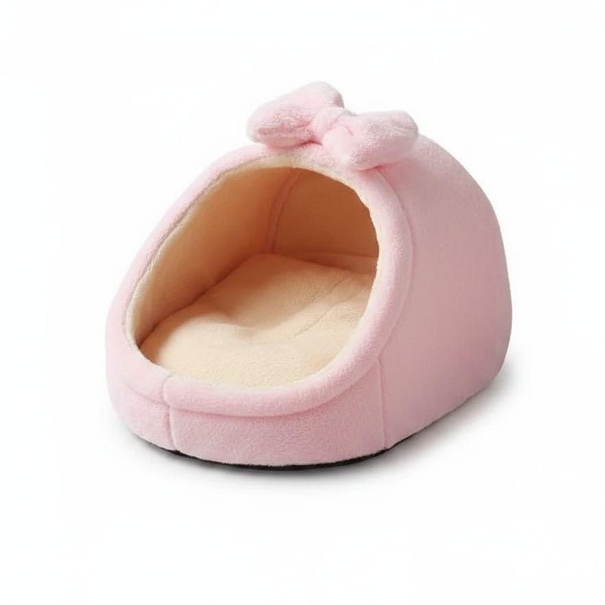 Soft pink plush igloo cat bed with fluffy bow detail and cream fleece interior, white background